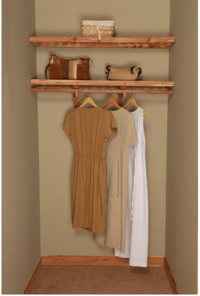 Clothing hanging on an aromatic cedar wooden shelves against a beige wall.