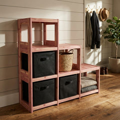 Wooden cube storage unit with shelves and bins in a room with wooden floor and white walls.